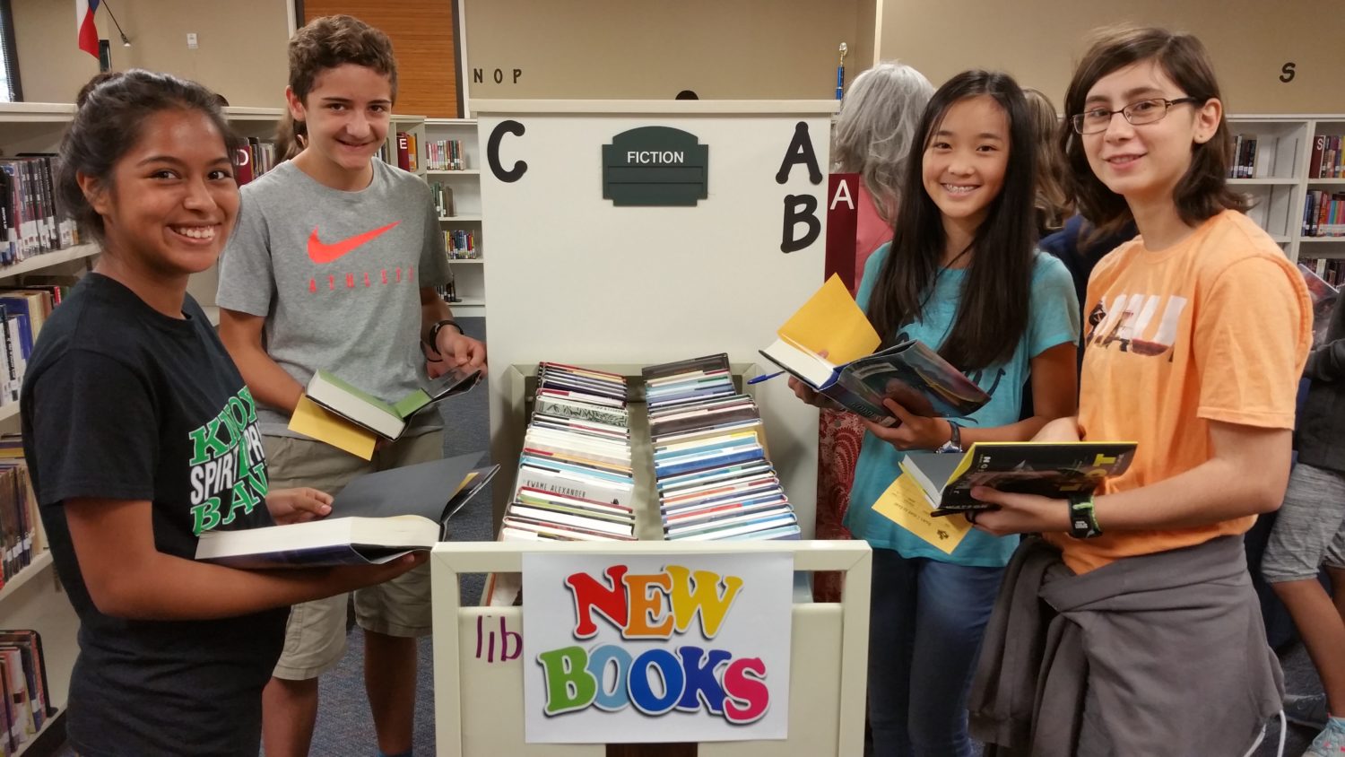 Eighth grade students at Knox explore the new book arrivals in the library.