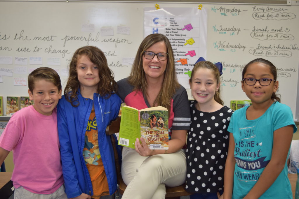 Mitchell Intermediate LC 11 students pose with Ms. Thorpe and their current read aloud novel.