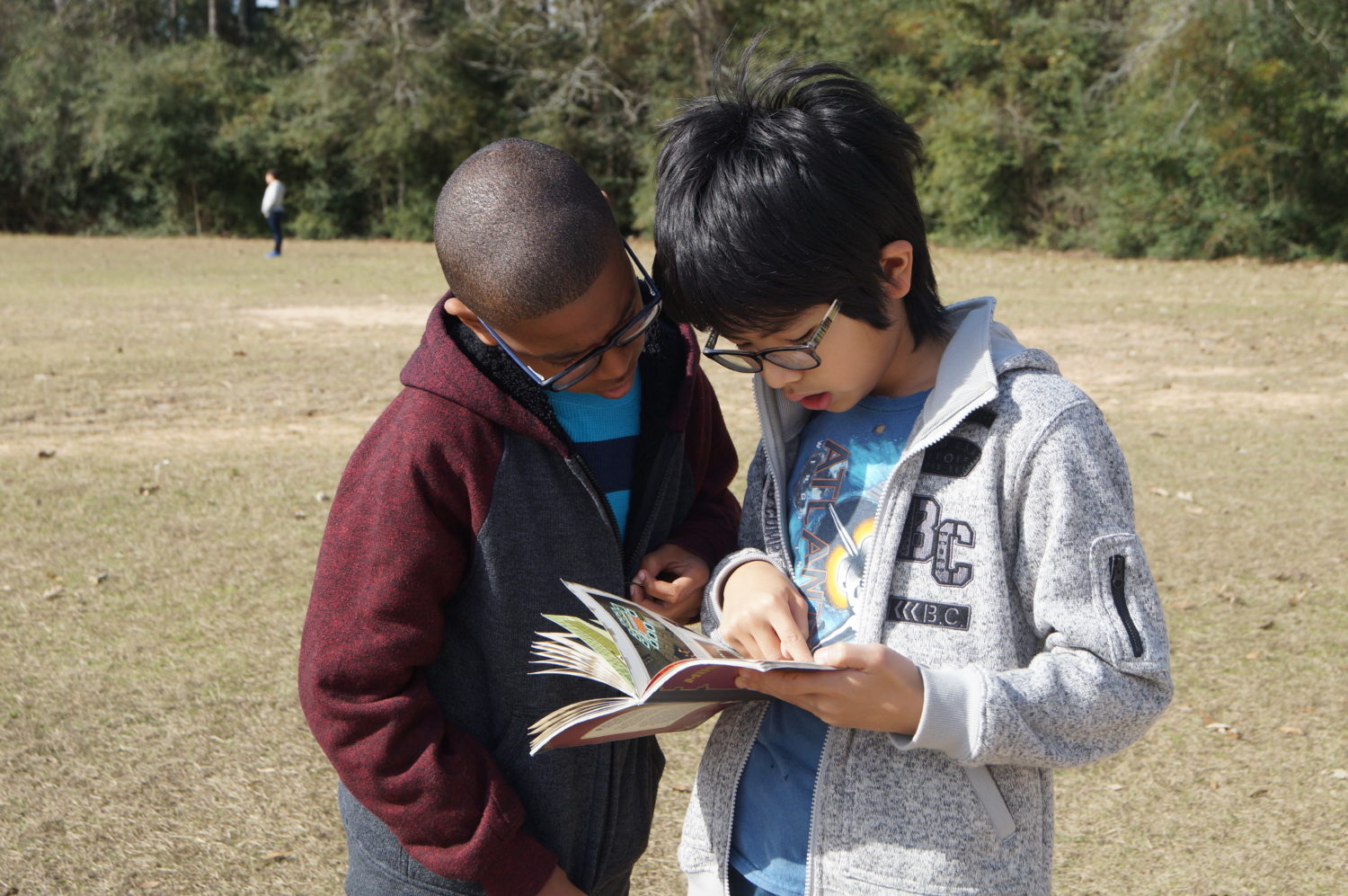 Collins students share a good book while enjoying the outdoors.