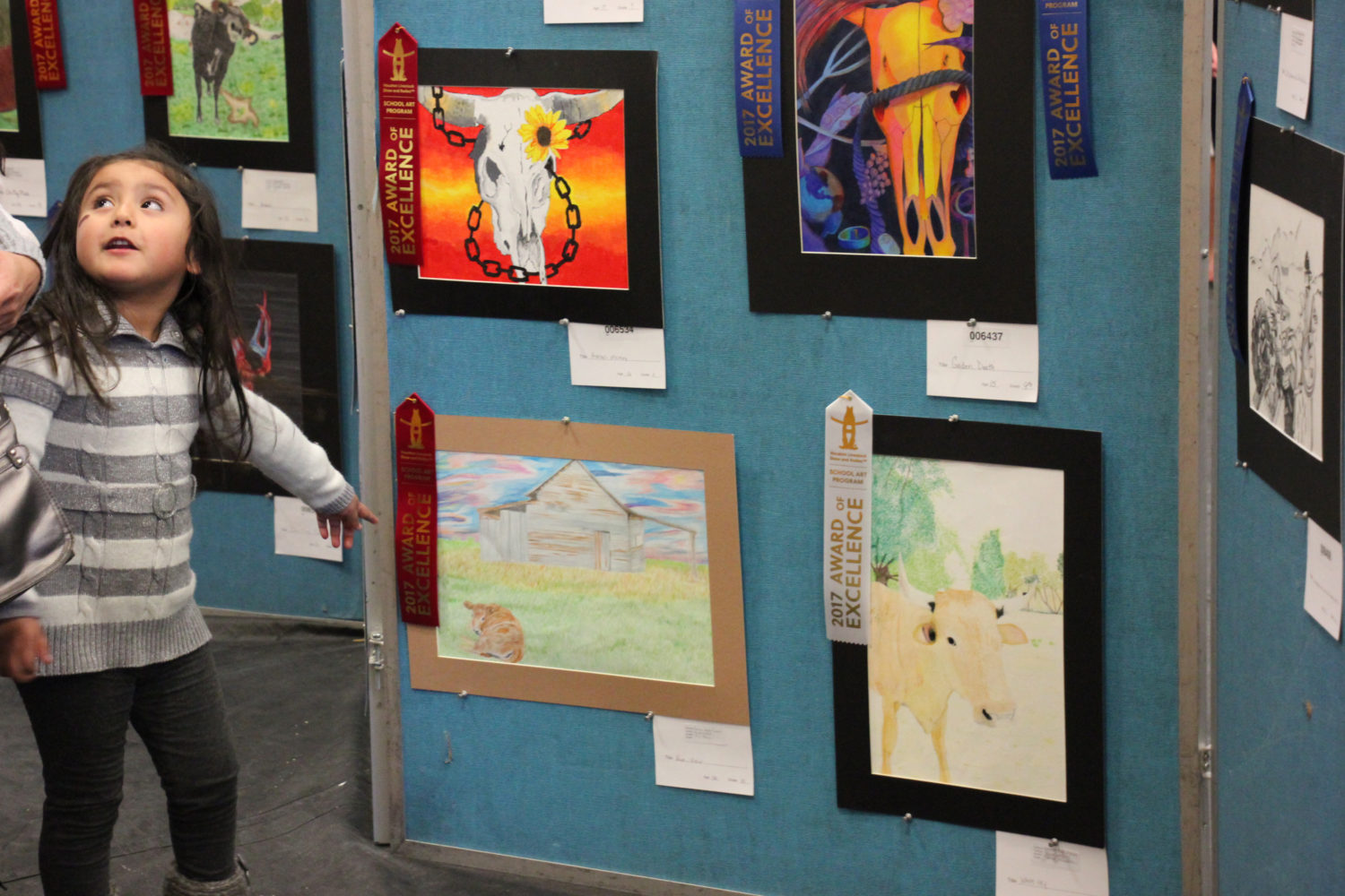 An attendee at the Western Art show points out a favorite piece.