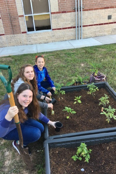 Students from Vogel Intermediate work together on planting seeds in the new school garden.