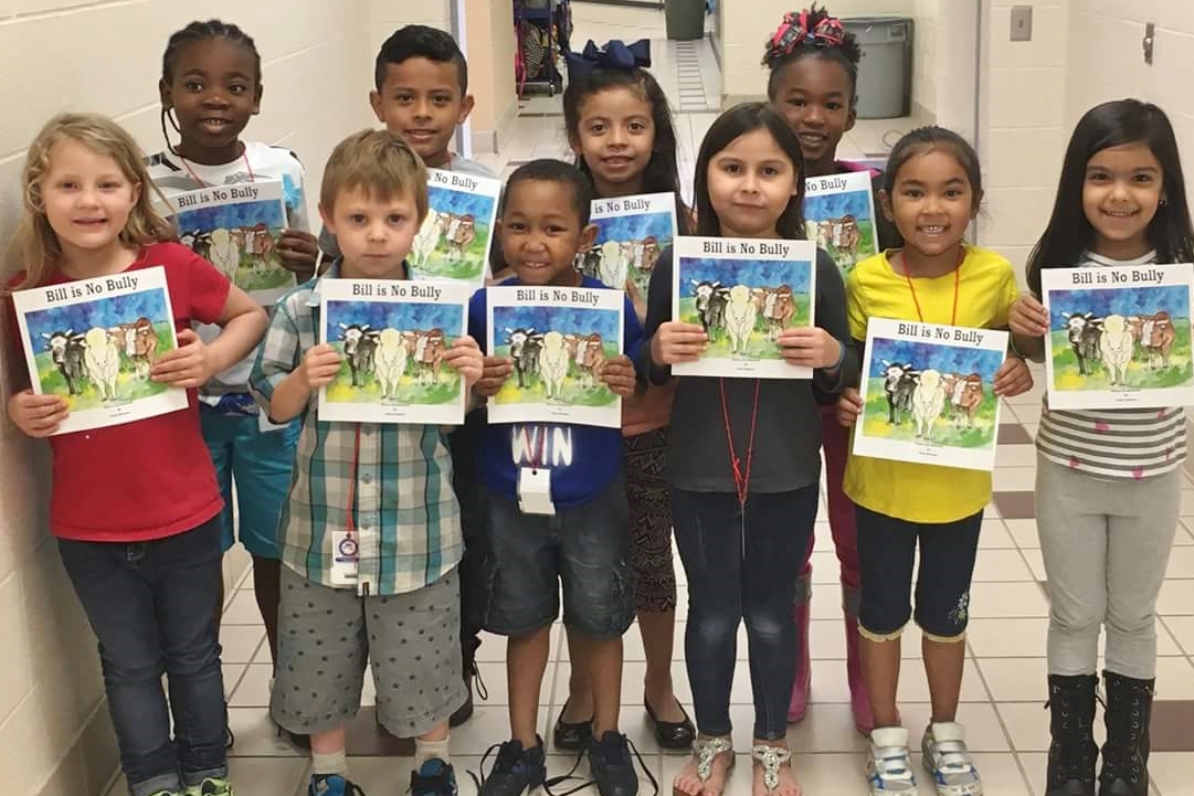 Students at Armstrong Elementary take time so show off their reading selection for the week.