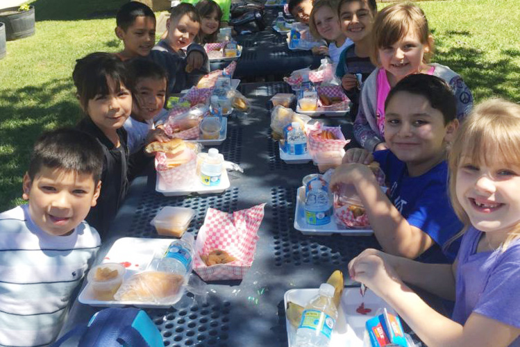 Second grade students at Creighton Elementary enjoy the nice weather while eating lunch.