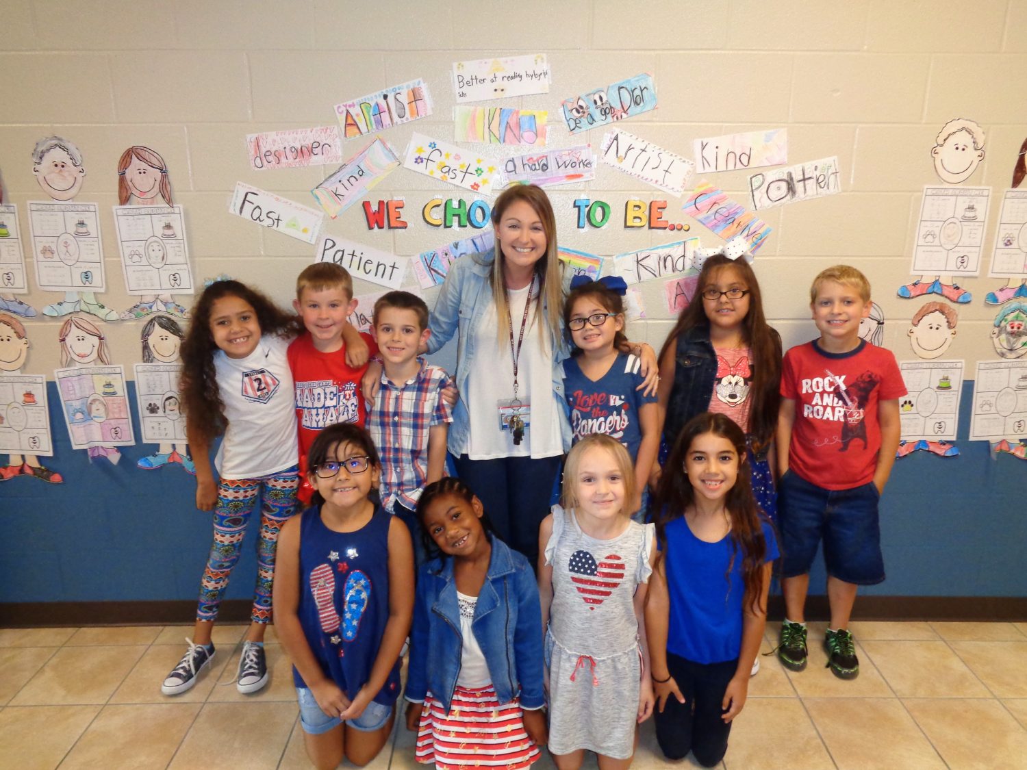 a class in patriotic clothing pose with their teacher