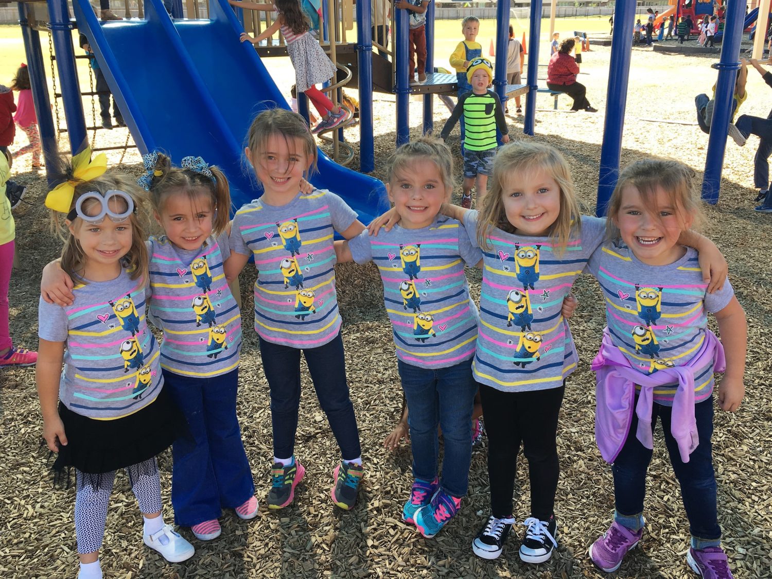 a group of six girls wearing the same shirt smile
