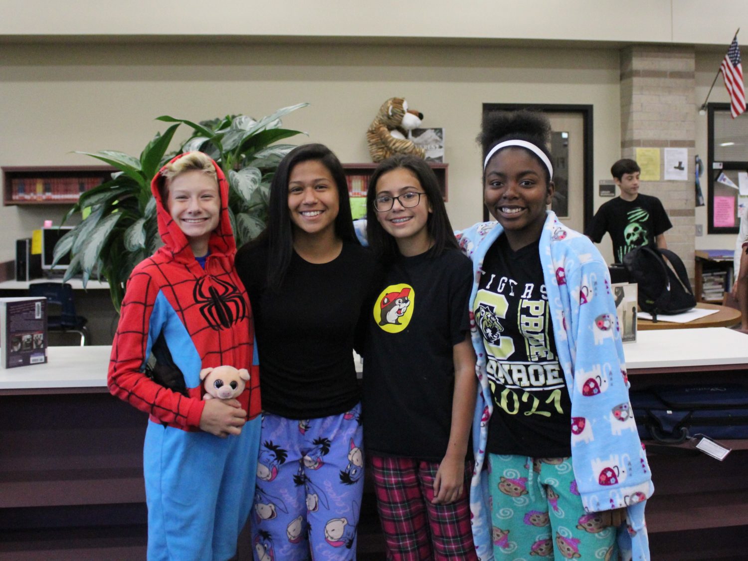 four girls pose for a picture while wearing their pajamas
