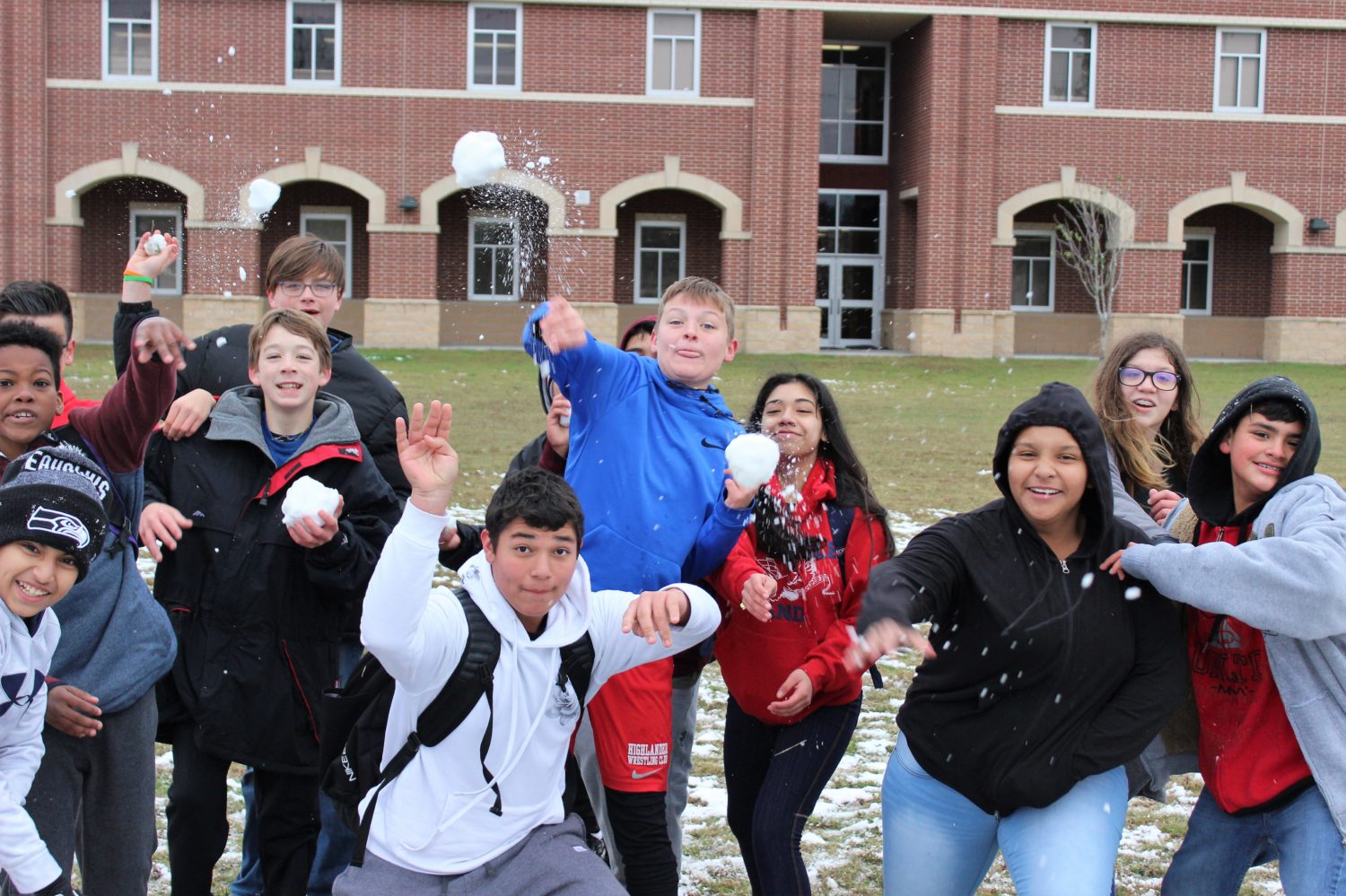 group of children throw snowballs