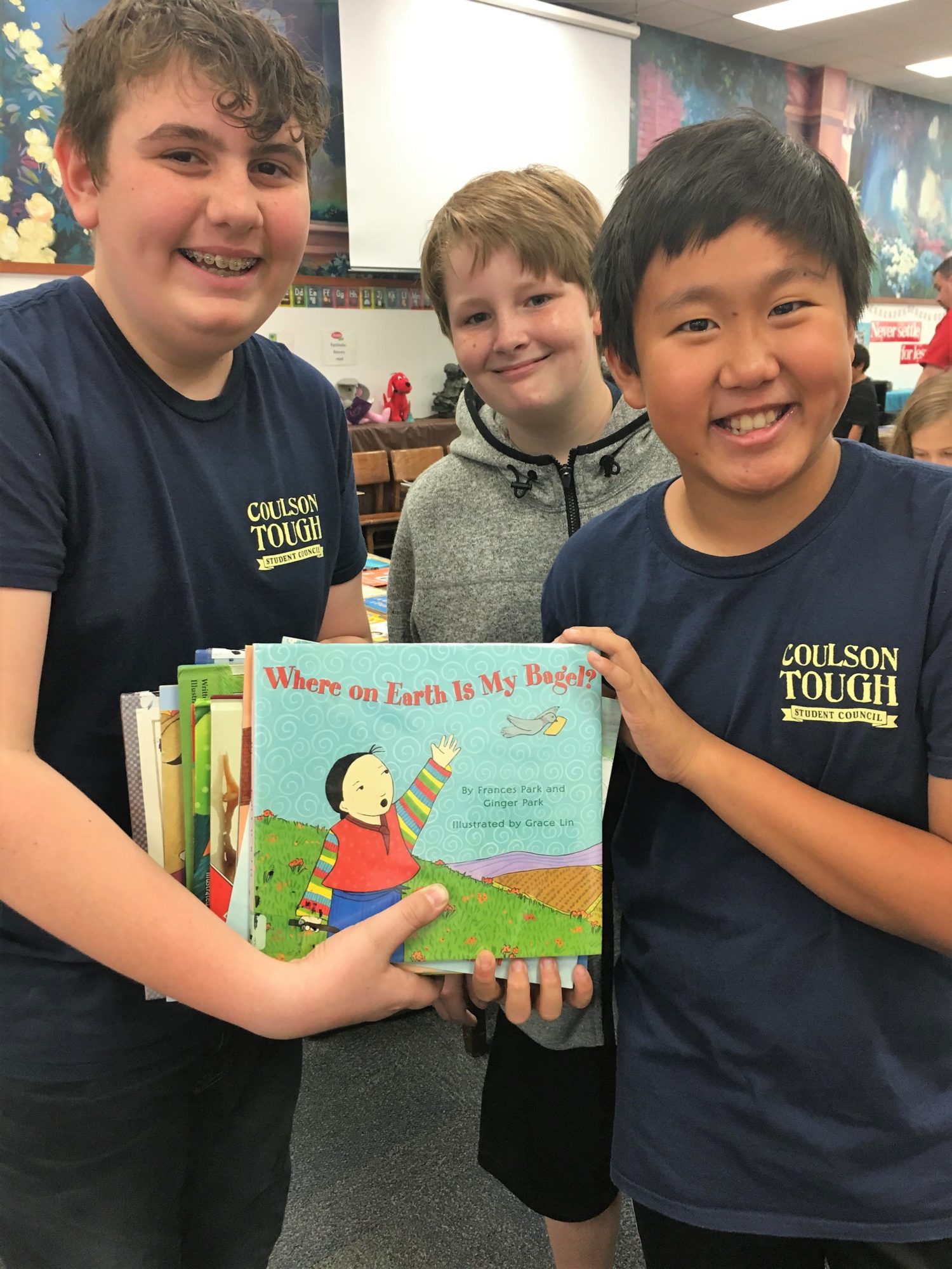 group of boys hold up a book