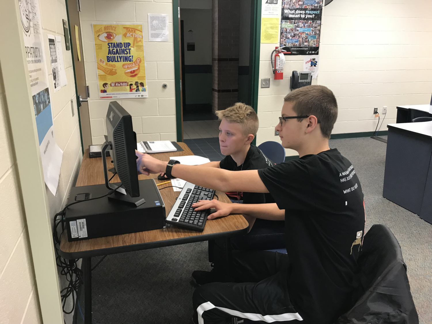 two boys work on a computer as part of a cyber security team
