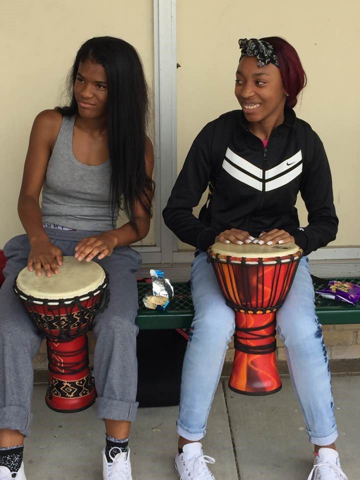 two girls learn to play the drums