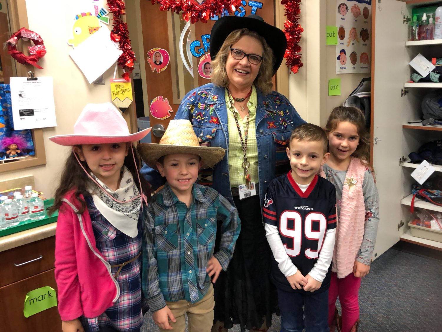 four students in western wear pose with their school principal