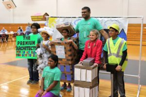 A diverse group of elementary students pose while wearing home-made costumes.