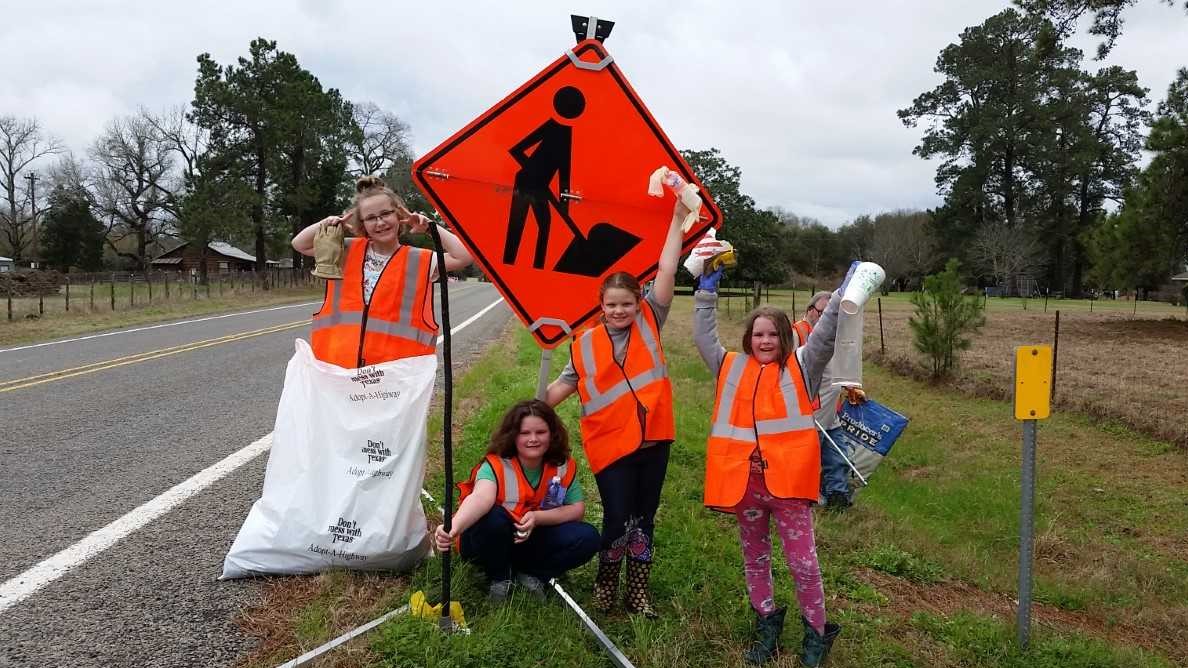 a group of children volunteer to clean a 4 mile stretch of road