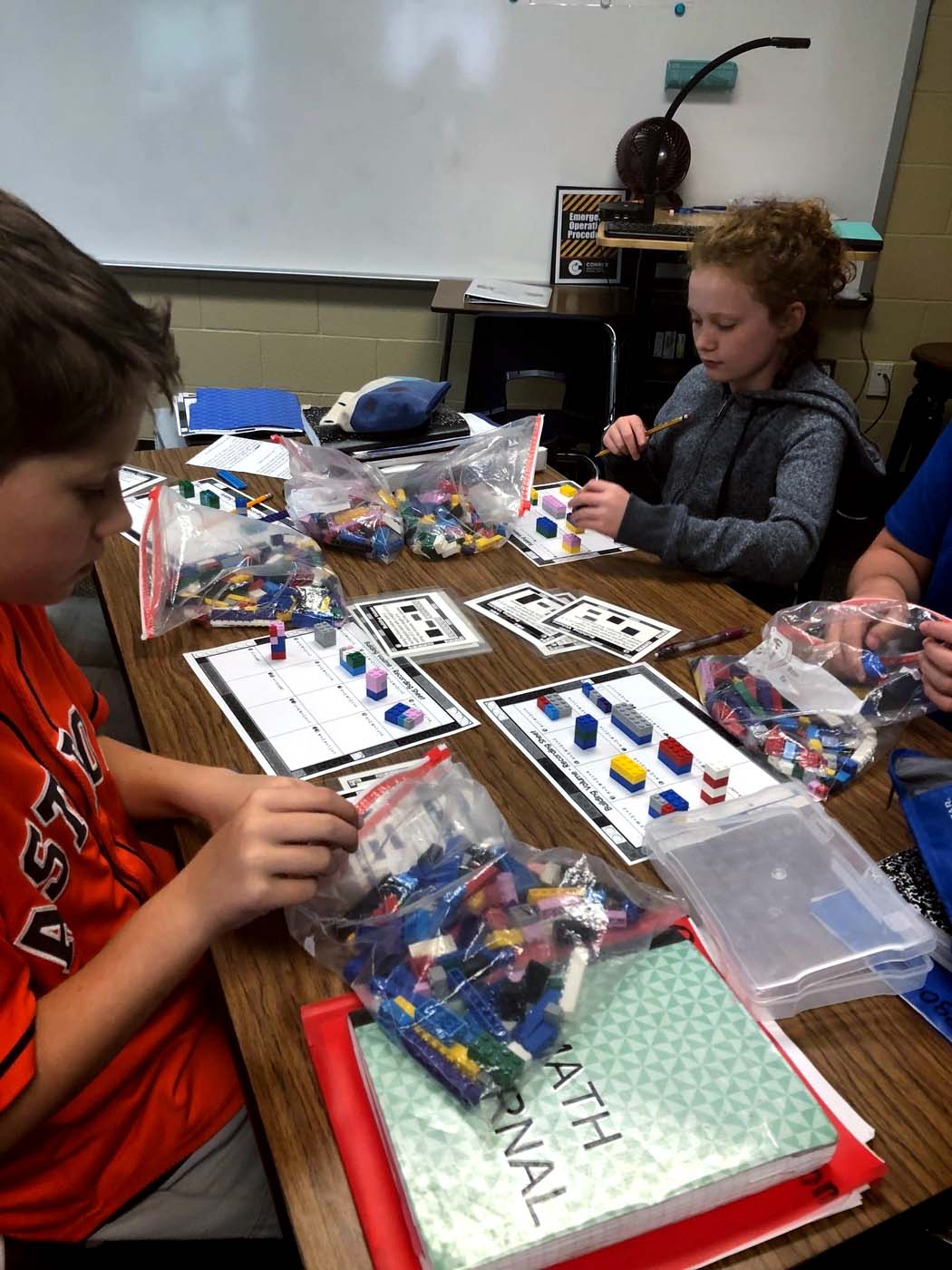 "three students learn about volume with Legos"
