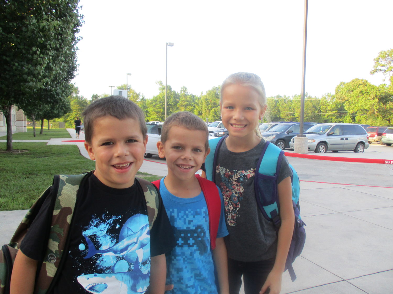 three students smile on the first day of school
