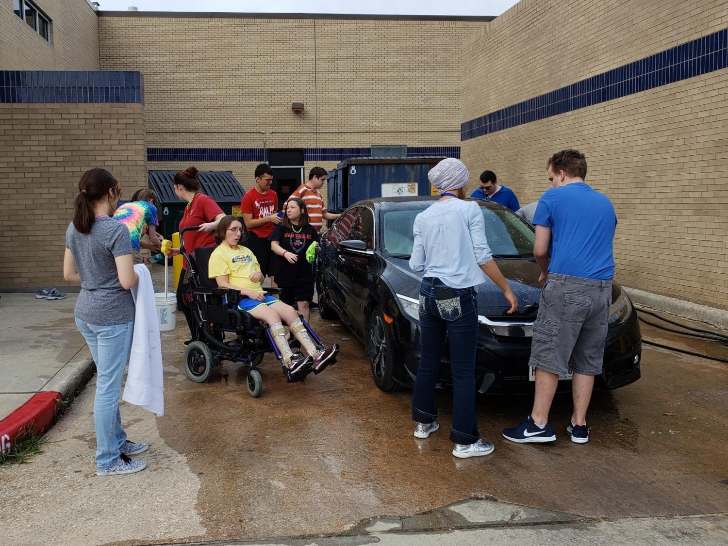 "a group of kids wash a car"
