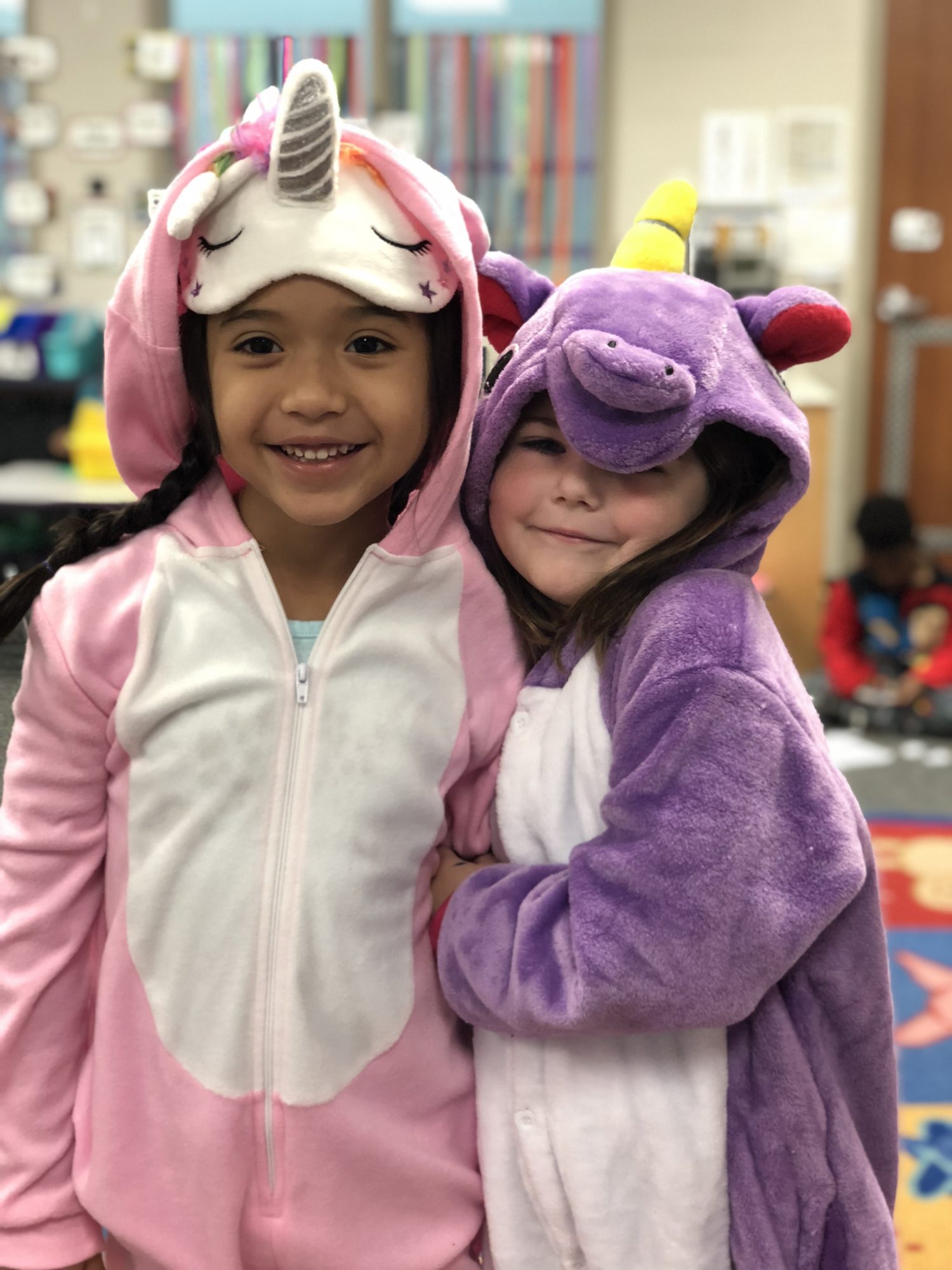 "two girls wear unicorn pajamas"