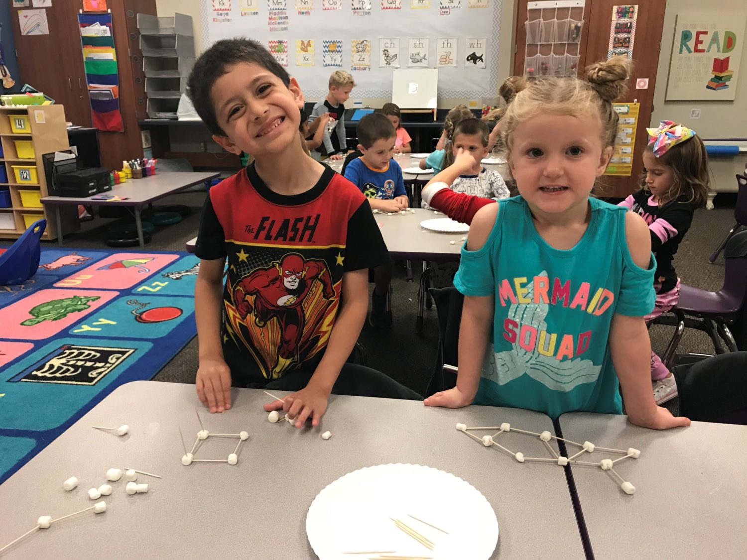 "a boy and a girl build with marshmallows"