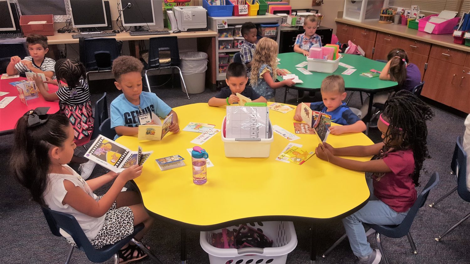 "a group of students read books while sitting at their desks"