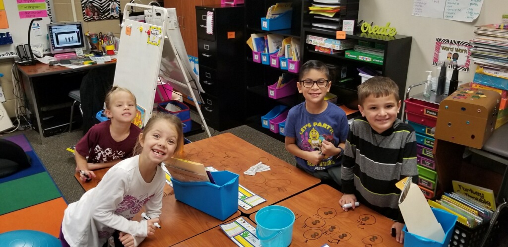 "a group of four students work on counting money"