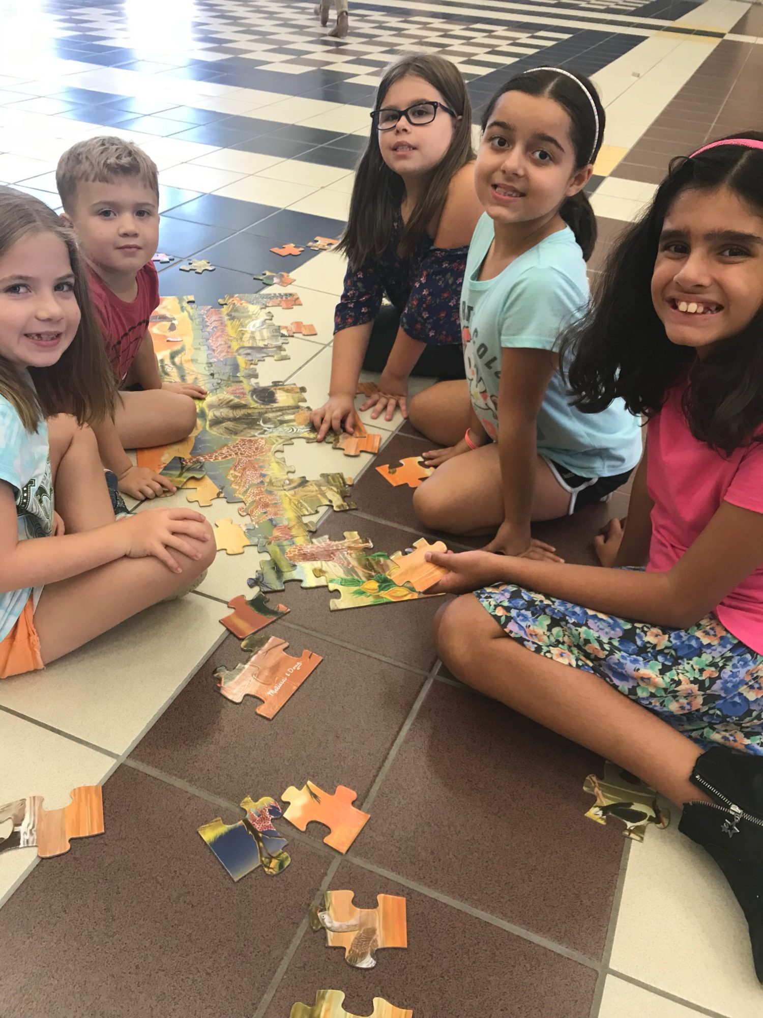 "a group of students build a puzzle"
