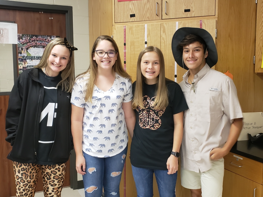 "four students pose for a picture wearing safari themed clothing"