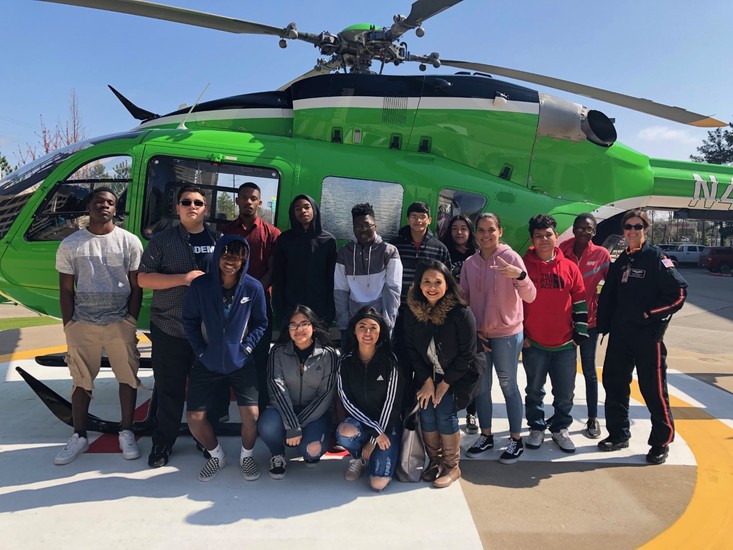"students pose in front of a medical helicopter"