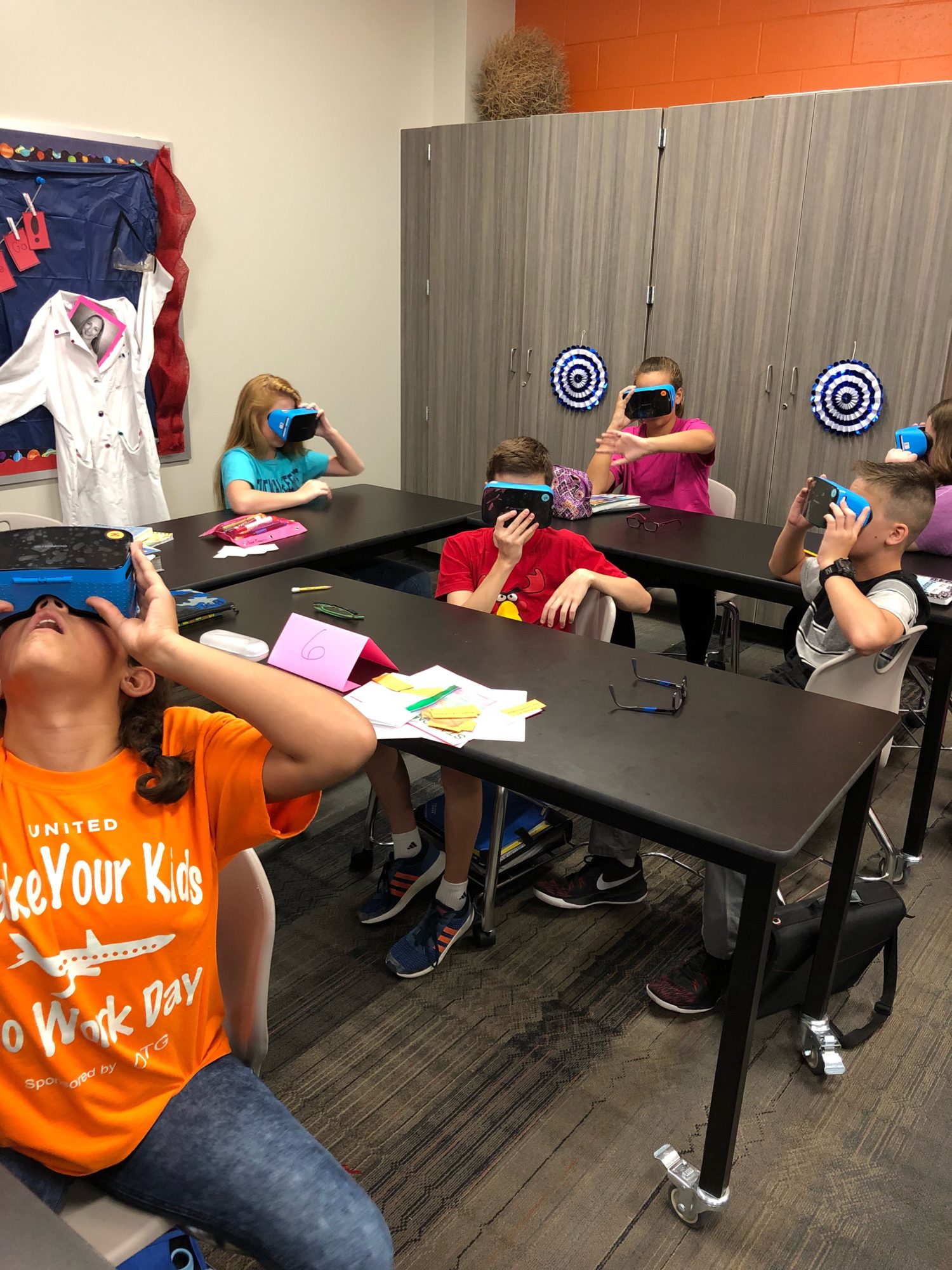 "students look through VR goggles"