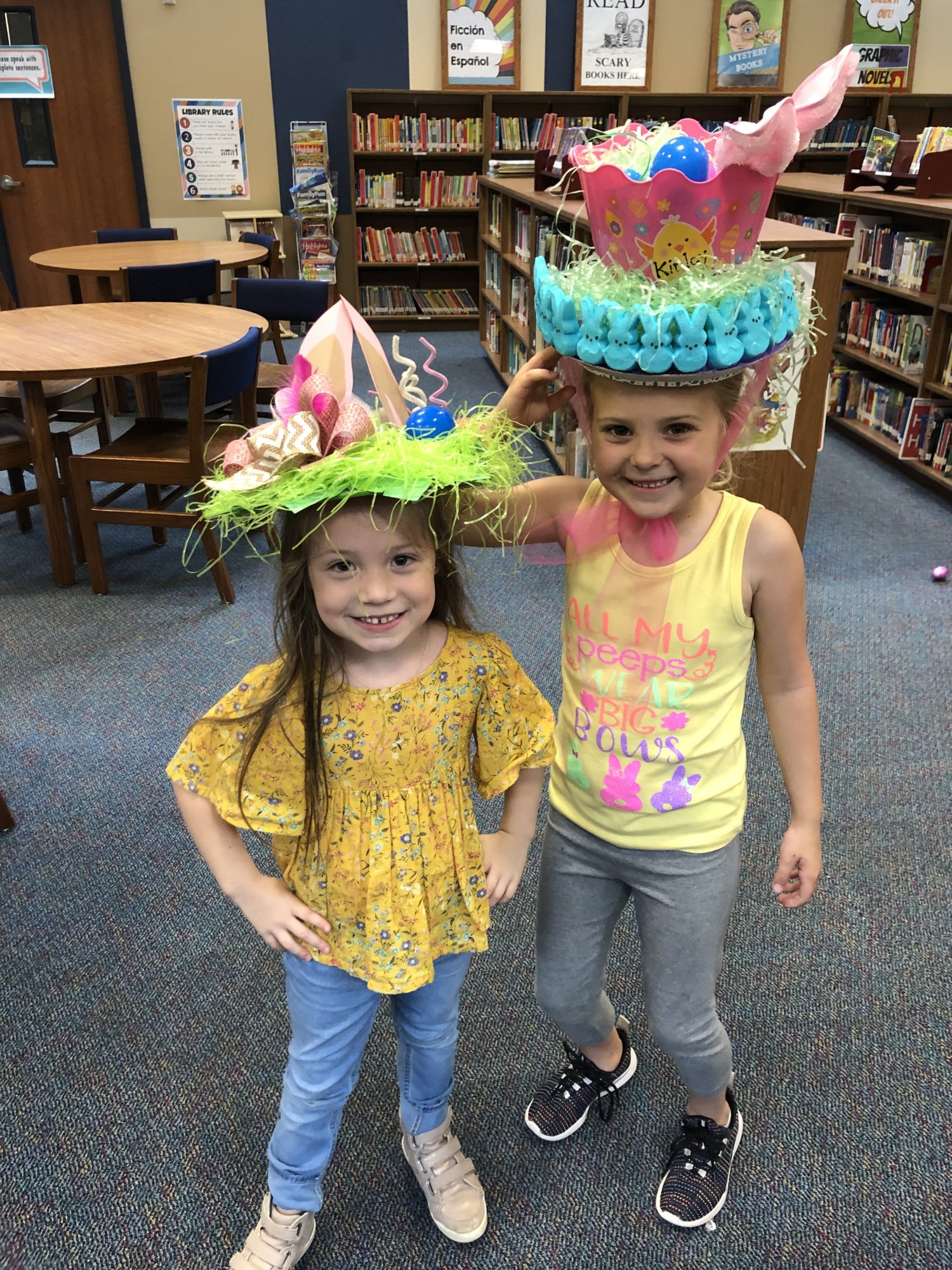 "two girls wear Easter hats"