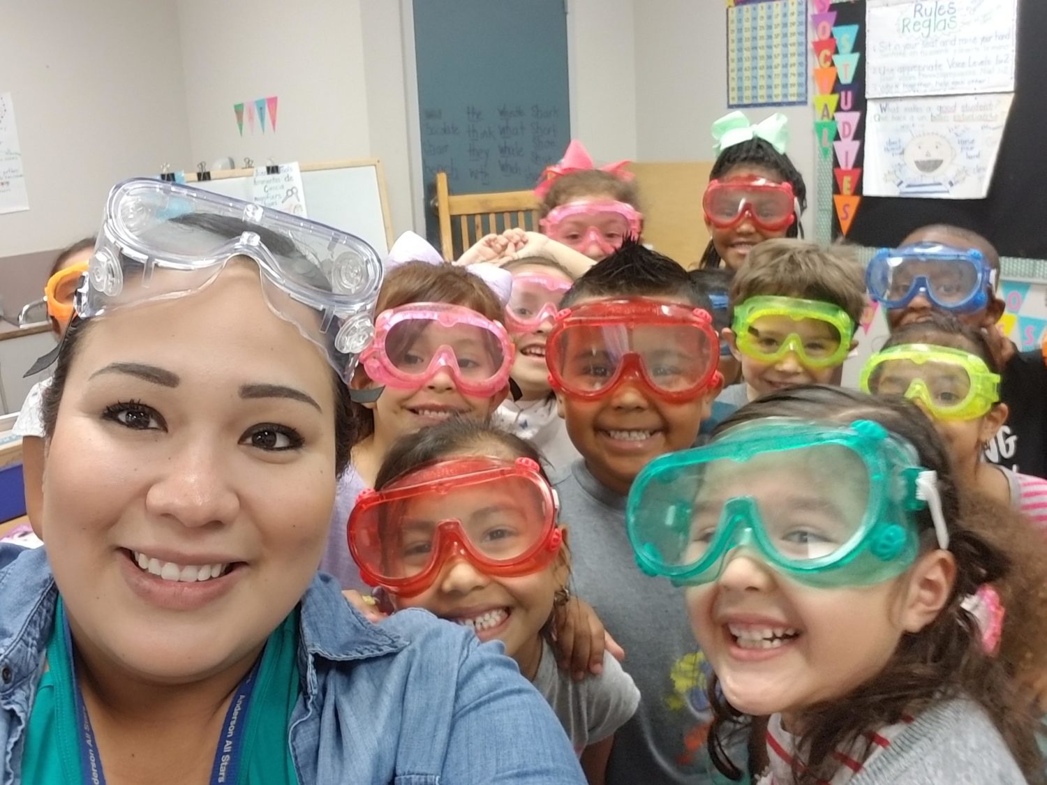 "a teacher and her class wear safety goggles"