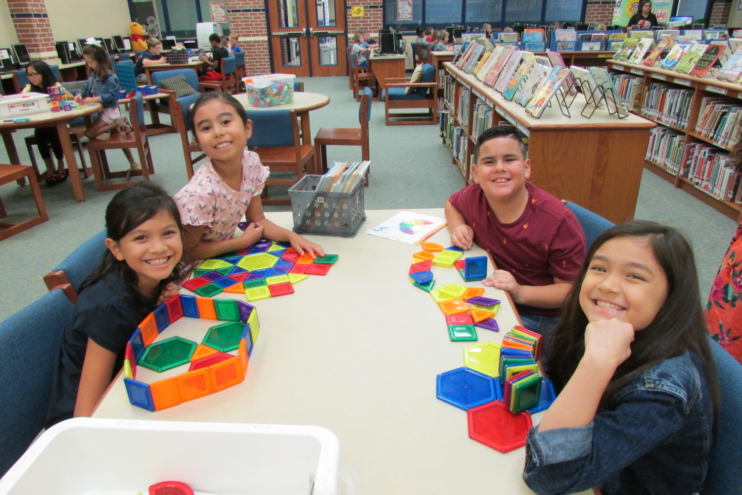 "four students play with Legos"