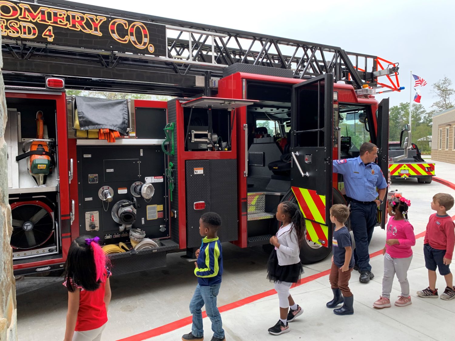 "students walk in front of a fire truck"