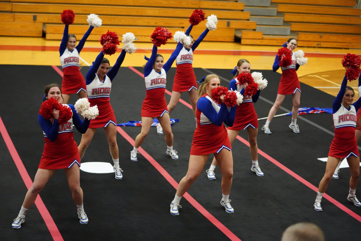 "cheerleaders perform in a gymnasium"