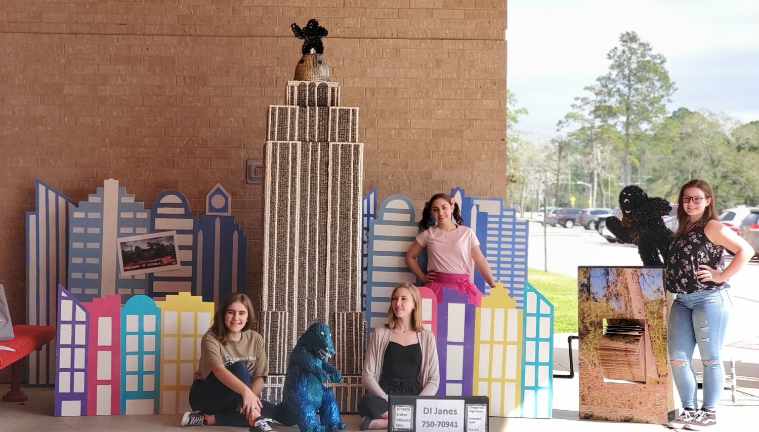"students pose in front of the Empire State Building they replicated made out of shelled sunflower seeds"