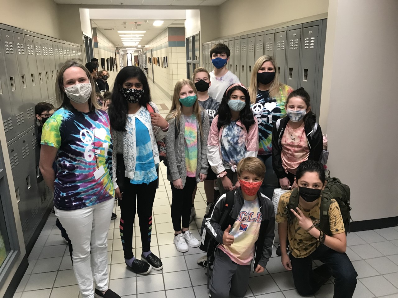 Students and Teachers smile for the camera while wearing tie-dye