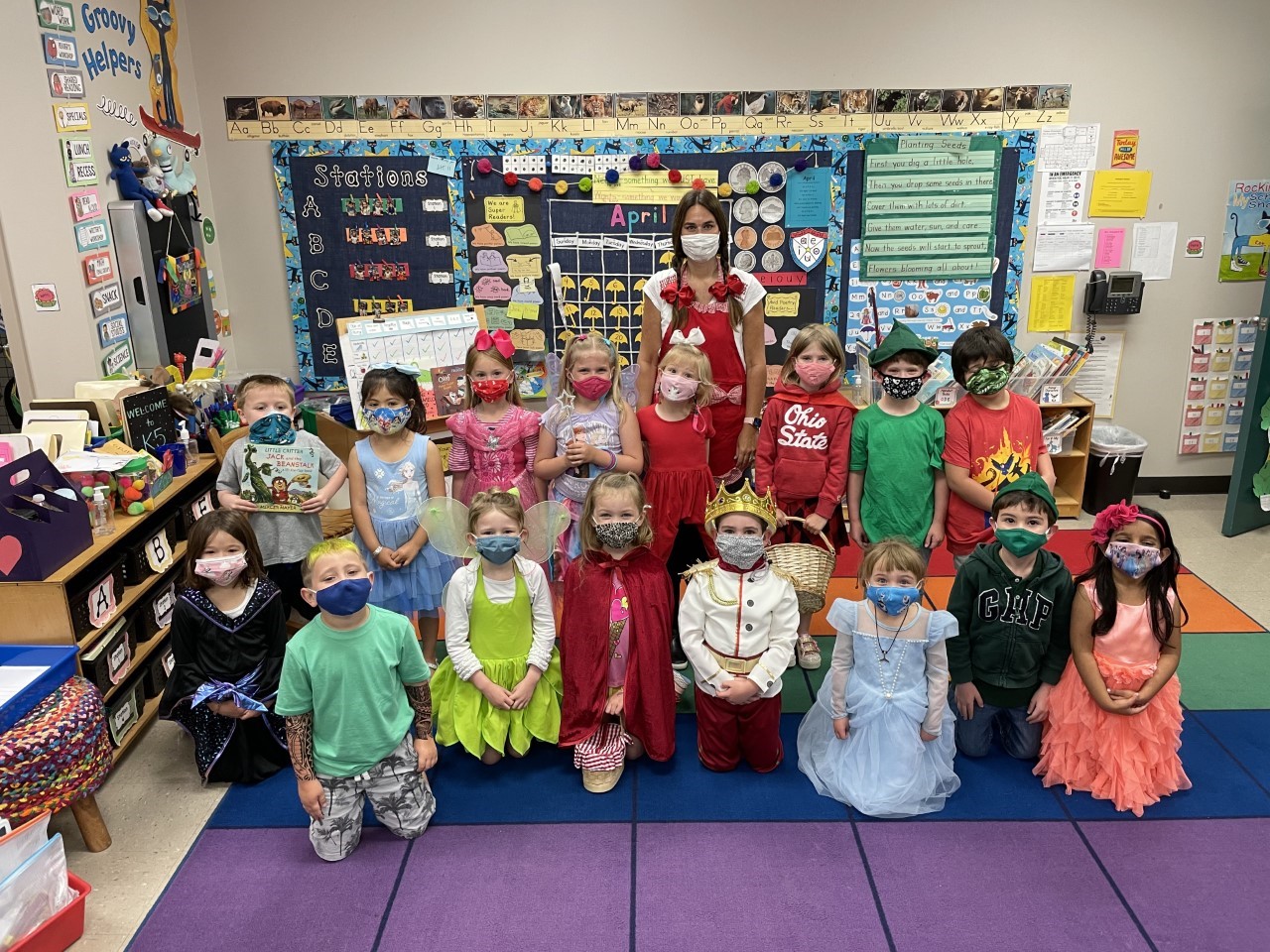 "A group of students smile for a picture while wearing fairy tale costumes.