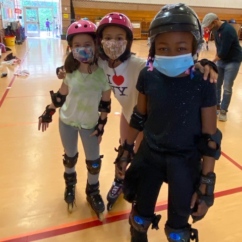 Students smile for the camera while roller skating.