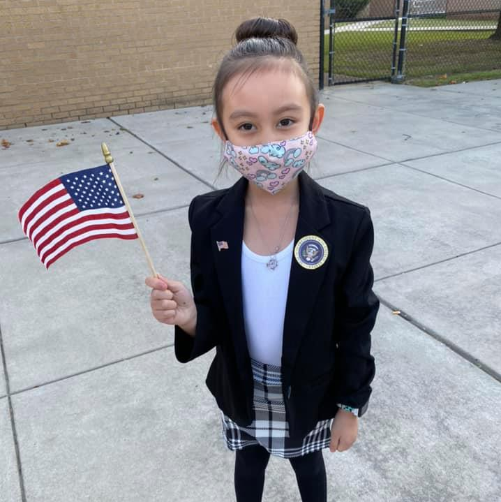 A student smiles for the camera while holding a flag.