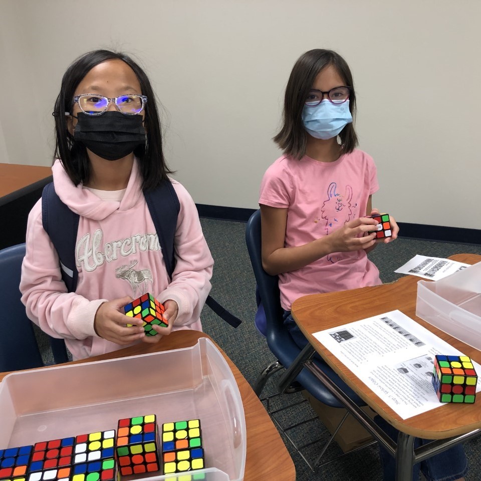 Two students do an activity with Rubik's Cubes.