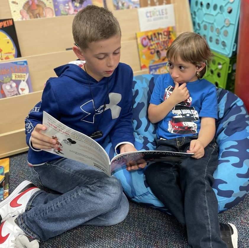 Two students read a book together.