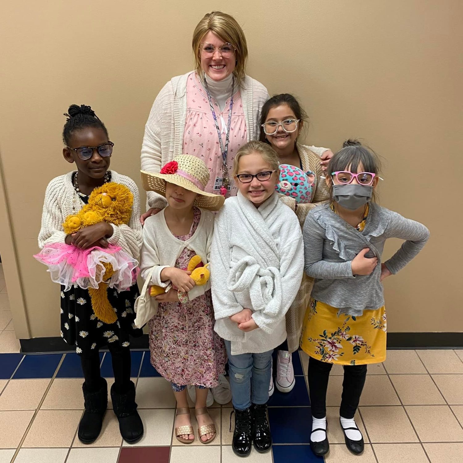 Students smile with their teacher on the 100th Day of School.