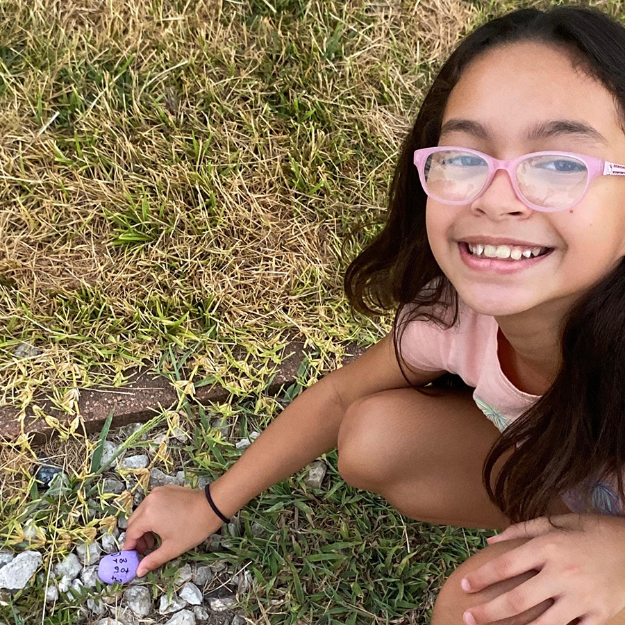 Student placing a kindness rock on the ground