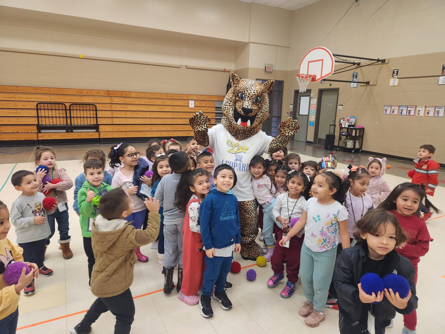 Lamar Elementary mascot Leo the Leopard visits students in the gym.