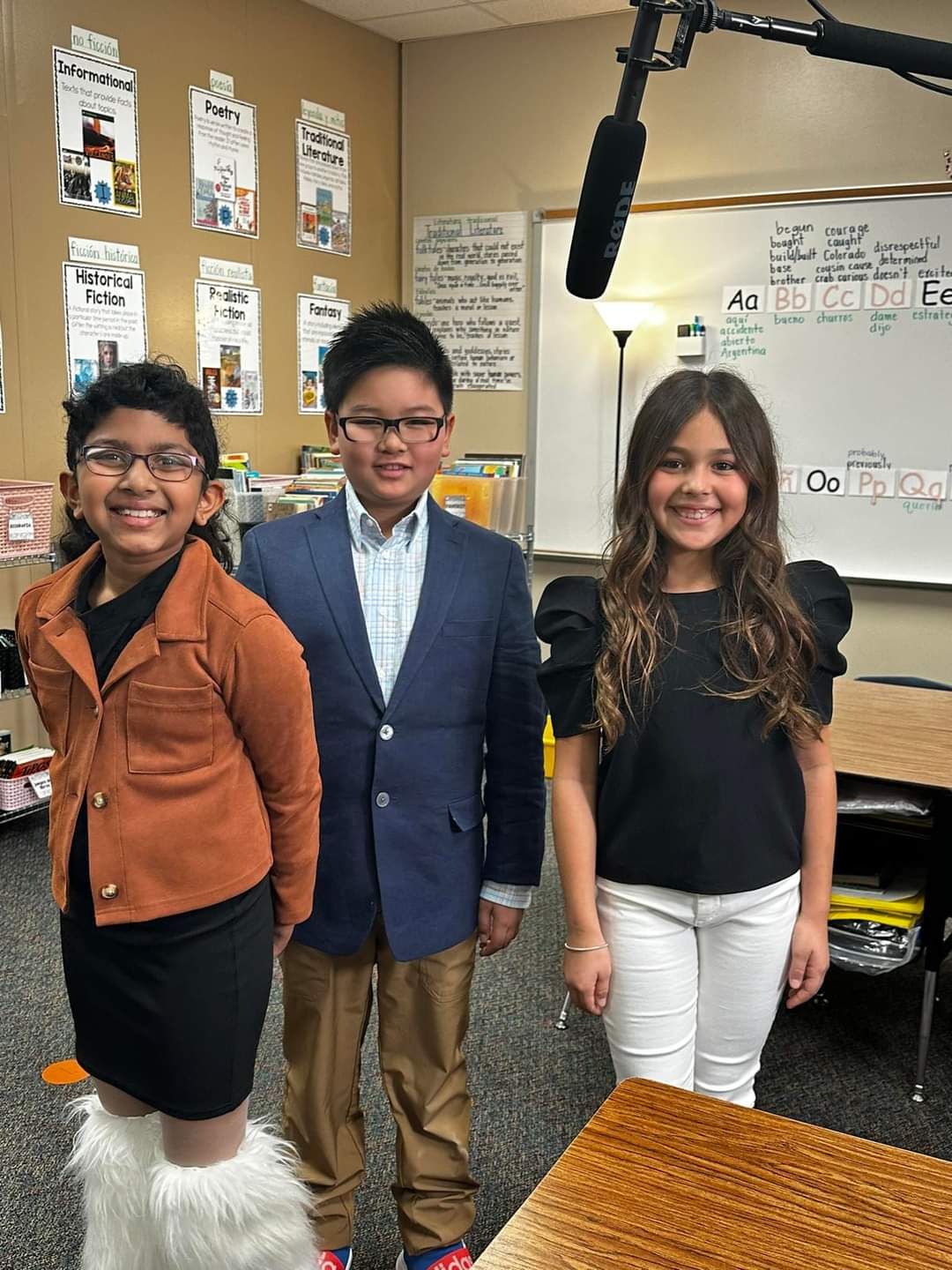 Three students pose with a microphone after filming a commerical.